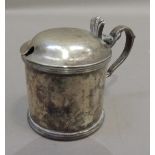 A George V silver lidded mustard with fluted thumb piece and reeded bands, scroll handle, 6cm high