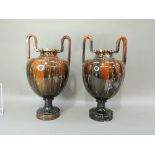 A pair of two handled vases in the classical style with baluster bodies, waisted stems and