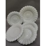 A set of five white glazed pottery dishes by Makkum comprising four 25.5cm diameter and a serving