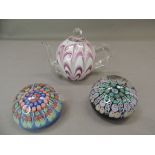 A Victorian pink and white glass teapot paperweight together with two modern millefiore paperweights