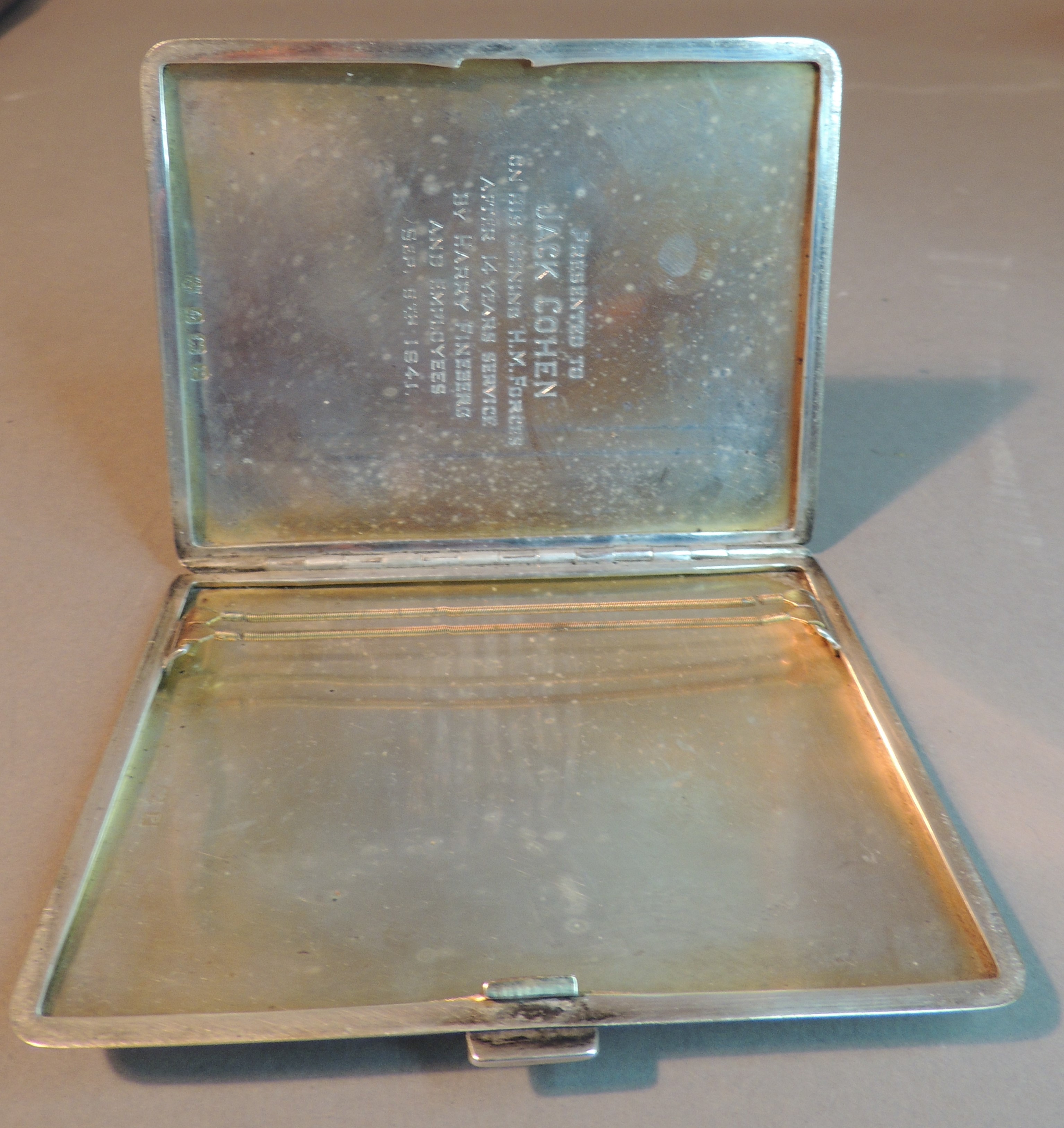 A George VI engine turned cigarette case, the front with rectangular cartouche with crest and