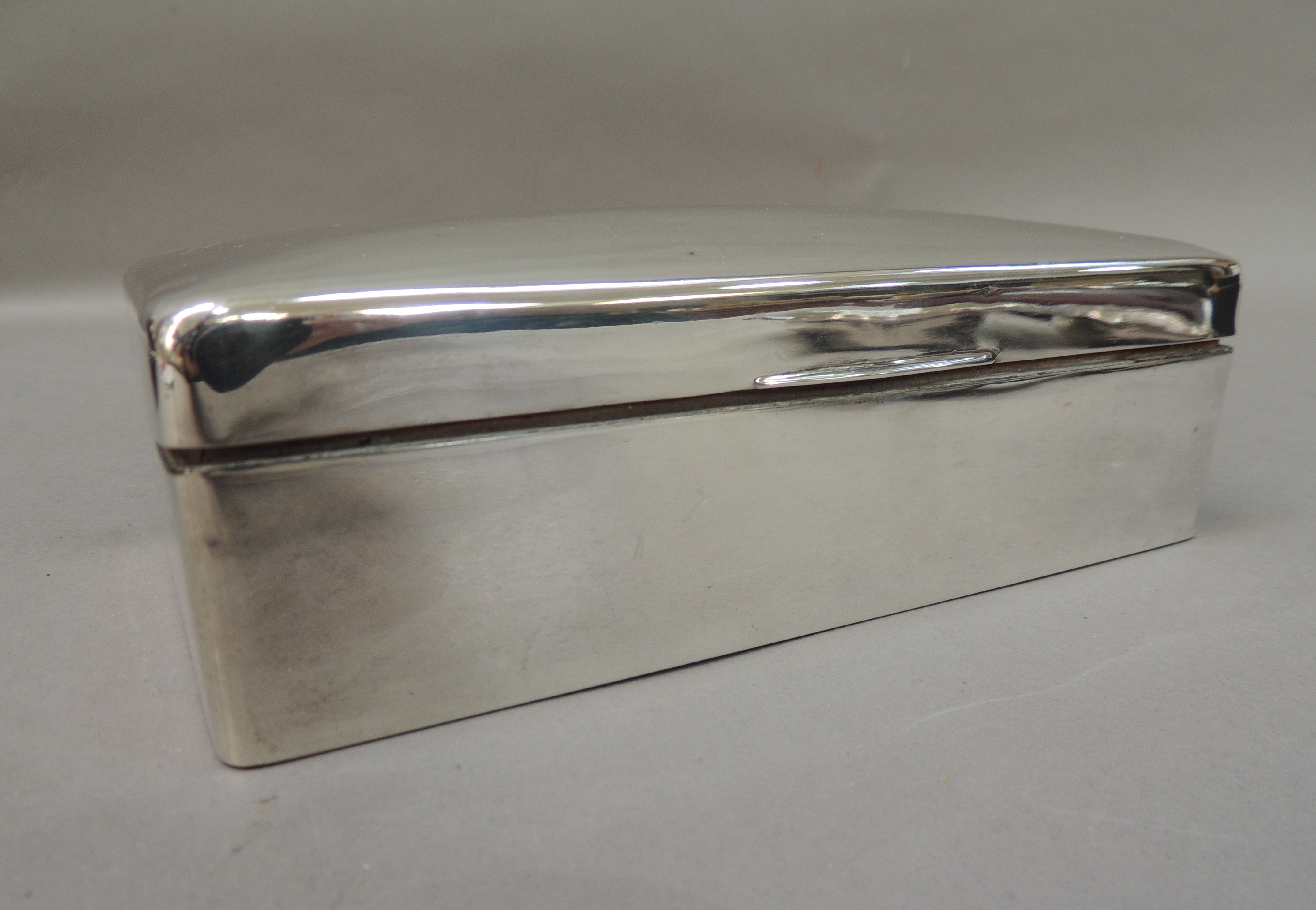 A rectangular silver cigarette box, slightly domed hinged lid, plain front, indistinct makers