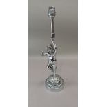 A Chromium plated figural lamp modelled as an infant holding a torch aloft on a spreading foliate