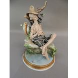 A Naples porcelain figure of an elderly sleeping fisherman seated on the banks of a stream, 25cm