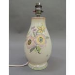 A Poole pottery table lamp, painted with daffodils and other flowers on a cream ground, shape no.
