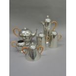 A Nick Munro polished pewter six piece tea and coffee service with raffia wrapped handles and ball