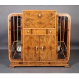 An Art Deco figured walnut mirror veneered drinks and display cabinet, with ivory Bakelite handles