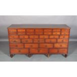 A 19TH CENTURY MAHOGANY BANK OF GRADUATED DRAWERS, the rectangular top above thirty two drawers, all