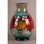 A WALTER MOORCROFT LEAF AND BERRY VASE, inverted baluster, form tube lined and painted in russet,