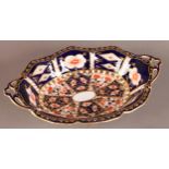 A ROYAL CROWN DERBY TWO HANDLED SHAPED OVAL DISH, pattern 6249, on four shallow scroll feet, 23.