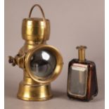A JOS LUCAS BIRMINGHAM BRASS LAMP with loop carrying handle, clear lens and red glass lens to the