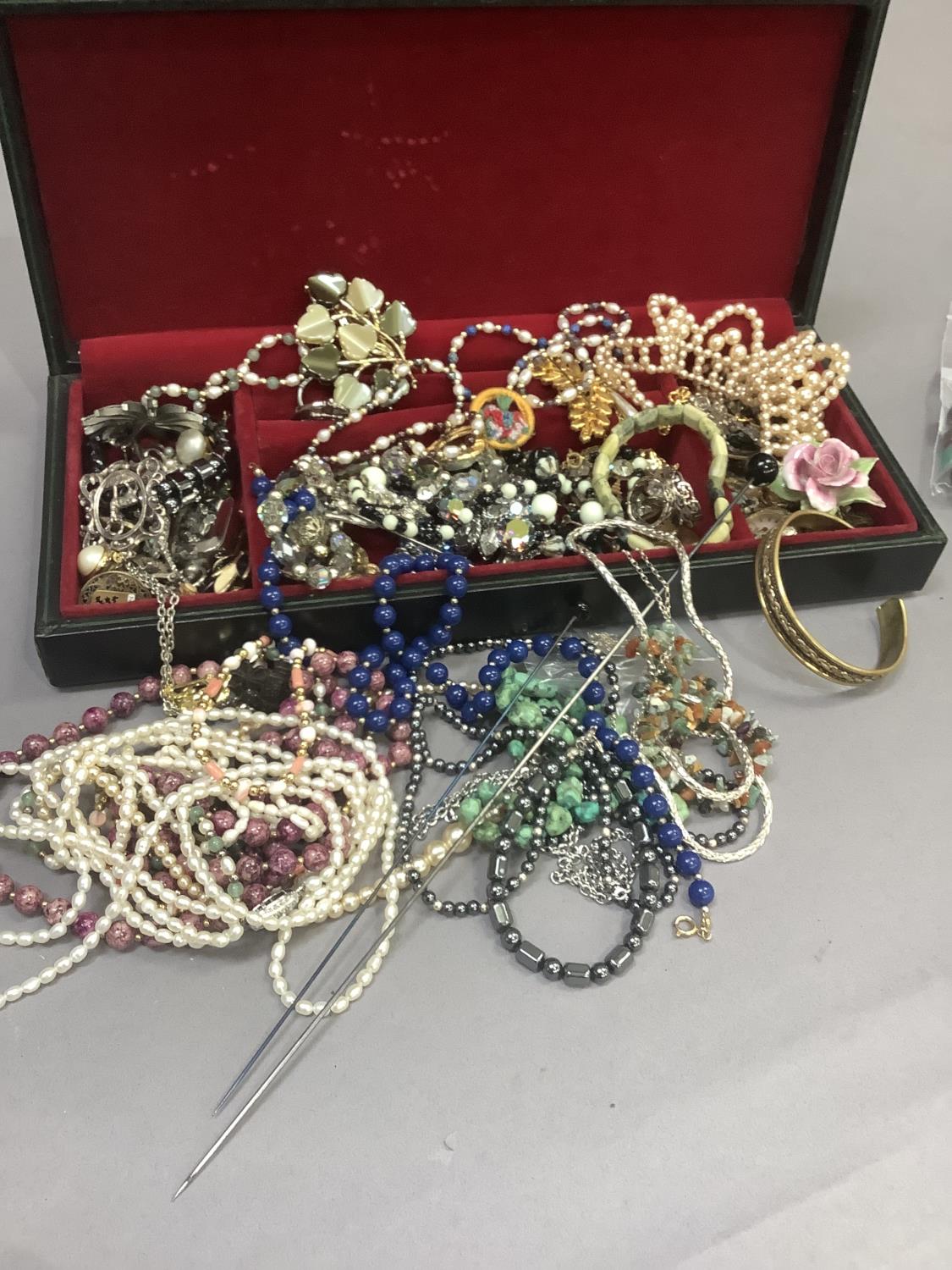 A collection of costume jewellery including necklaces, brooches, bracelets and bangles, each in a