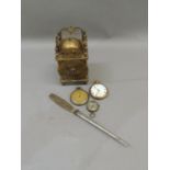 A reproduction brass skeleton clock, two pocket watches, a compass and a paper knife, the handle