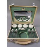 A 1950s vanity case fitted with a mirror, four lidded jars, four lidded bottles, a small rouge pot