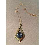 A blue topaz pendant, the oval faceted stone collet set within a lozenge shaped outline hung from
