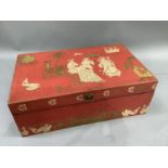 A chinoiserie storage box of red ground printed with figures in a garden landscape, 41cm wide by