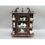 A glazed and shelved table top cabinet containing a selection of miniature china including a