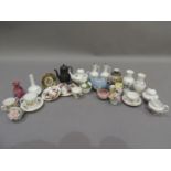 A collection of miniature china ornaments including a pair of vases, cups and saucers, teapot, sugar