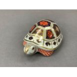A Royal Crown Derby paperweight in the form of a tortoise with gold button to underside