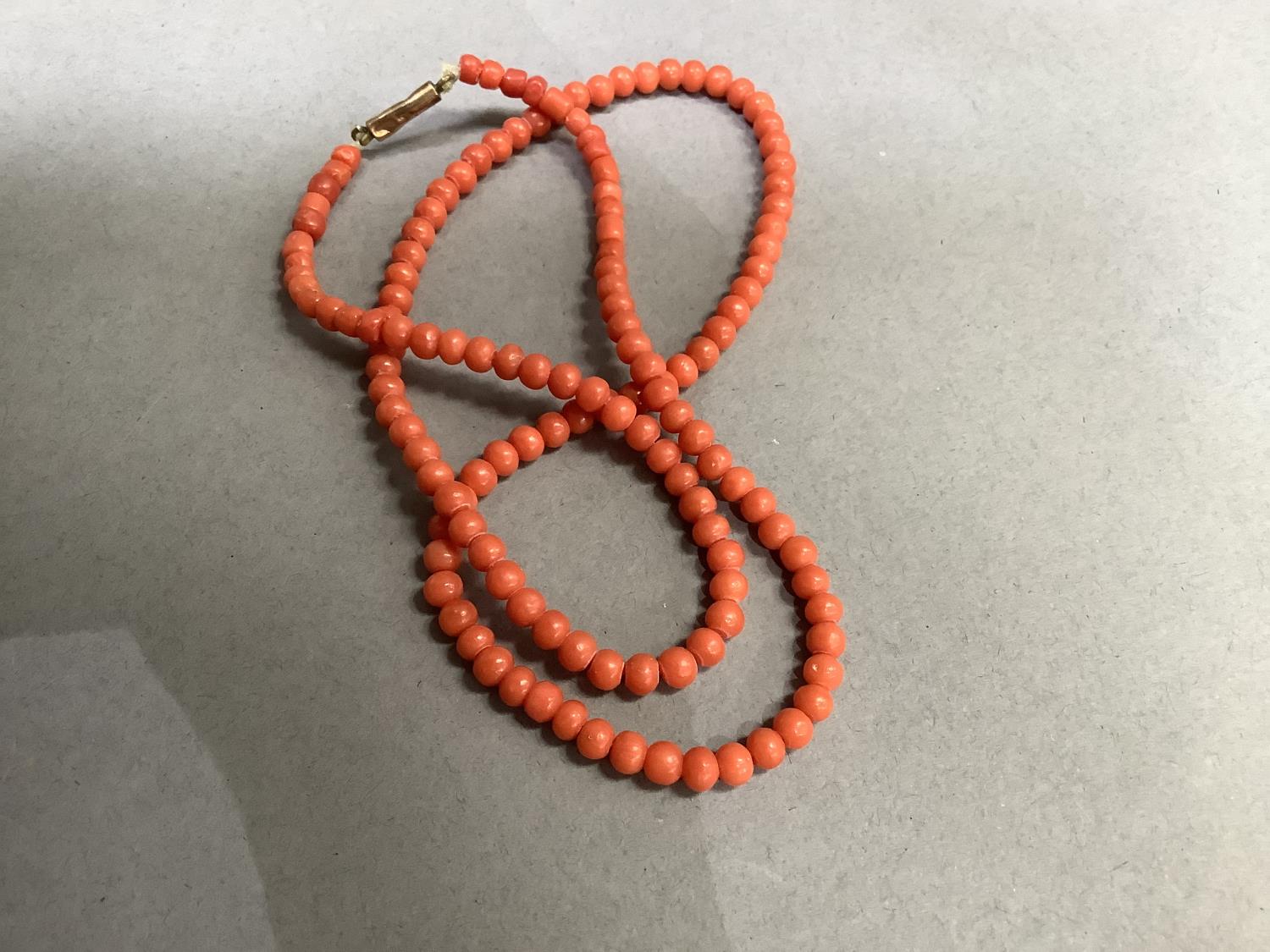 An early to mid 20th century coral bead necklace, the graduated roughly spherical beads fastened