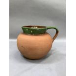 A Barum earthenware jug by C H Brannam Devon of rounded form with brown and green dipped neck and