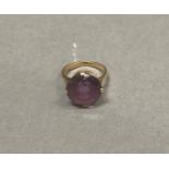 An amethyst dress ring, the circular faceted stone claw set in rose metal (tests as 18ct gold),