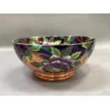 A Maling ware fruit bowl of orange and blue lustre printed with a border of peony and a butterfly to