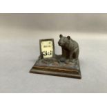 A Bavarian carved wood desk stand modelled as a bear containing a ceramic inkwell, with perpetual