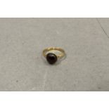 A garnet cabuchon 'carbuncle' ring, the circular stone collet set on an earlier 22ct wedding ring