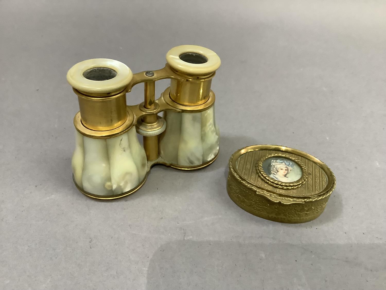 A pair of mother-of-pearl and gilt metal opera glasses together with a gilt metal jewel box of