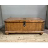 A reproduction cherry wood blanket chest, the hinged top carved to the centre with stylised