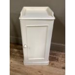 A cream painted Victorian pine bedside cupboard with three-quarter gallery and panelled door, with