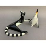 A Cmielow china figure of a black and white cat reclining, 12.5cm high by approximately 30cm long