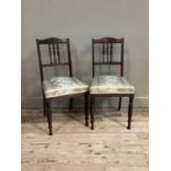A pair of late Victorian mahogany salon chairs with serpentine shaped cresting rails, roundel and