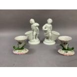 A pair of continental porcelain figures, fisherboys, each standing beside an open basket, 18cm high;