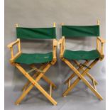 Two folding directors chairs with green canvas seats and backs
