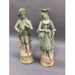 A pair of bisque figures of gallant and companion in pale green, highlighted in gilt, 38cm high