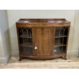 A reproduction mahogany bow front side cabinet in George III style, figured frieze above central