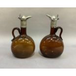 A pair of Victorian EPNS mounted and brown glass ewers with loop handles, 23cm high
