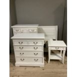 A five piece cream painted bedroom suite comprising chest of drawers fitted central panel cupboard