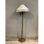 A standard lamp of turned, fluted, tapered form with foliate wrapped baluster base and foot,
