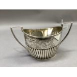 A Victorian two handled sugar bowl in George III style with reeded rim and angular handles, half
