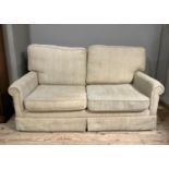 A two seater sofa bed in sand coloured fabric
