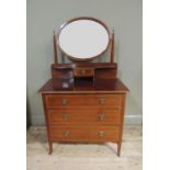 An Edwardian inlaid mahogany dressing table, the oval bevelled mirror supported on a pair of tapered