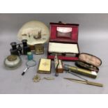 A leather bridge case with accessories, a miniature set of dominoes, pair of opera glasses, glass