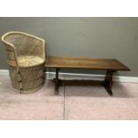 An oak refectory style coffee table with rectangular top, 106cm wide together with a wicker tub