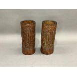 A pair of bamboo brush pots each carved in relief with figures amongst bamboo grove and pine
