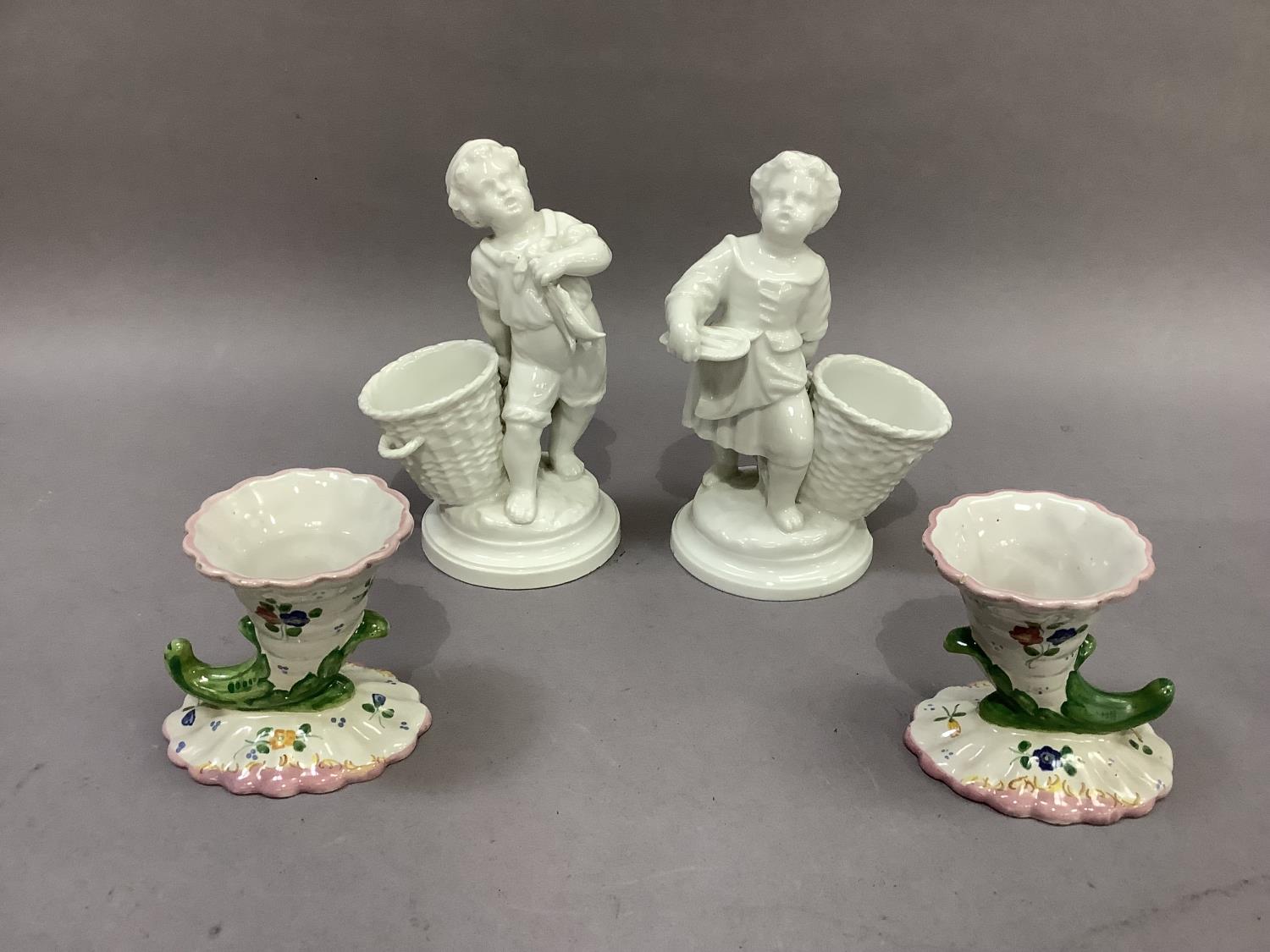 A pair of continental porcelain figures, fisherboys, each standing beside an open basket, 18cm high; - Image 2 of 3