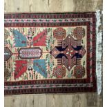 A reproduction caucasian style bordered runner, 310cm long by 74cm wide, fringed