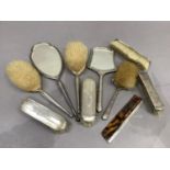 An Edwardian five piece silver backed brush and mirror set together with a four piece mirror and